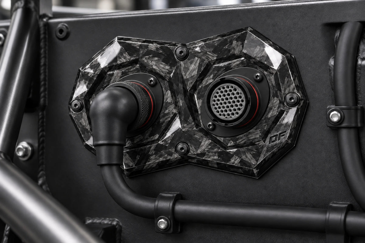 Large Dorifab dual forged carbon bulkhead plate installed on a motorsport firewall with a booted DR25 loom.